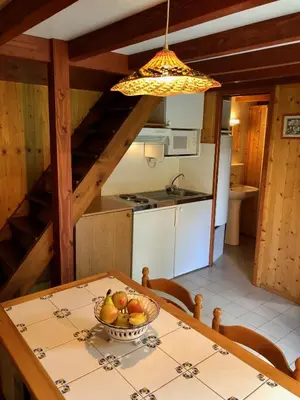 a kitchen with a table with a bowl of fruit on it at Chalet dans le parc d'un manoir du XIXème in Anglès