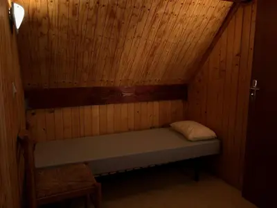 a small room with a bed in a wooden wall at Chalet dans le parc d'un manoir du XIXème in Anglès