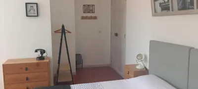 a bedroom with a bed and a dresser and a mirror at La maison de Malaurie in Gruissan