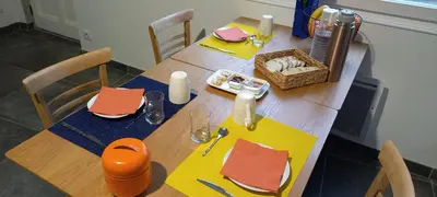 a wooden table with yellow and orange napkins on it at La maison de Malaurie in Gruissan