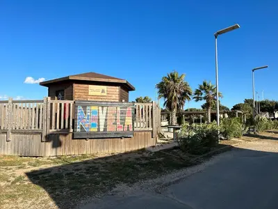 a fence with a mural on the side of a building at Mobil Home de Marine in Port-la-Nouvelle