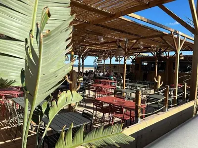 a restaurant with red tables and chairs and the ocean at Mobil Home de Marine in Port-la-Nouvelle