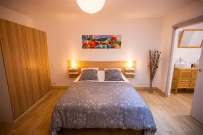 a bedroom with a bed and a painting on the wall at Gîte du Montagut in Thézan-des-Corbières
