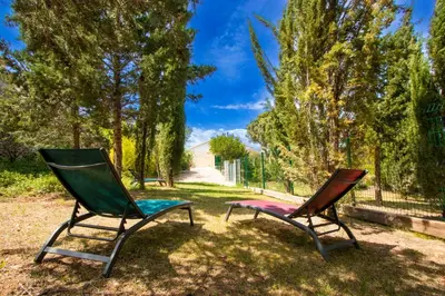 two chairs sitting in the grass in a yard at Gîte du Montagut in Thézan-des-Corbières