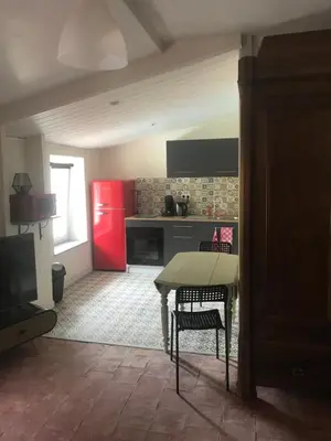 a kitchen with a table and a red refrigerator at Douceur occitane in Saint-Chinian