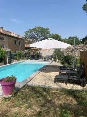 a pool with two lounge chairs and an umbrella at Douceur occitane in Saint-Chinian