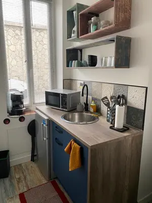 a small kitchen with a sink and a microwave at Au pied du centre ville - Mignon petit studio climatisé in Narbonne
