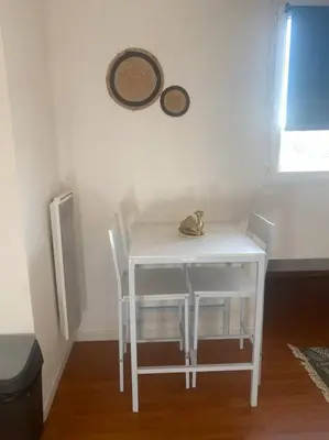 a white table and chairs with a cat sitting on it at Proche des plages - Beau T2 climatisé in Narbonne