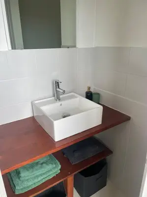 a bathroom with a white sink and a mirror at Proche des plages - Beau T2 climatisé in Narbonne