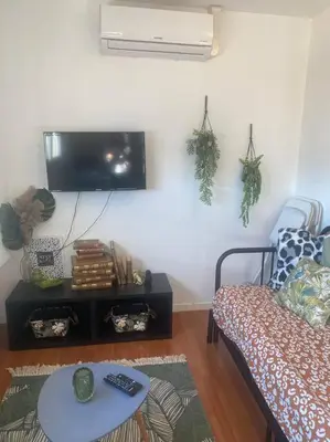 a living room with a couch and a tv on the wall at Proche des plages - Beau T2 climatisé in Narbonne