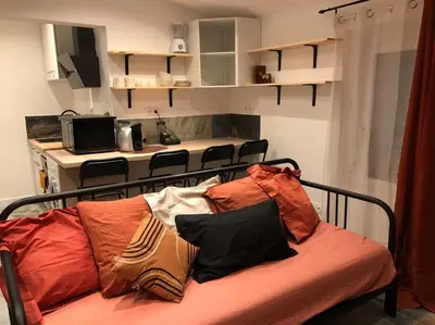 a couch with pillows on it in a room at Charmant T2 climatisé - Près des plages in Narbonne