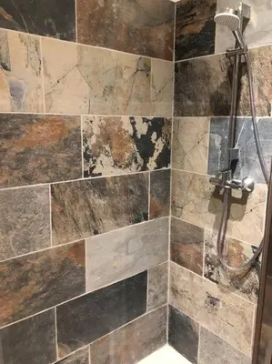 a bathroom with a shower with a stone wall at Charmant T2 climatisé - Près des plages in Narbonne