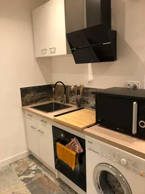 a kitchen with a sink and a washing machine at Charmant T2 climatisé - Près des plages in Narbonne