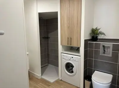 a bathroom with a washing machine and a toilet at Chez Gaëlle in Trèbes