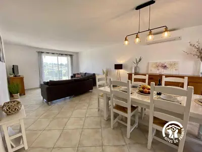 a living room with a white table and chairs at Les iris in Castelnau-dʼAude