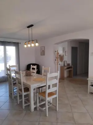 a living room with a table and chairs and a couch at Les iris in Castelnau-dʼAude