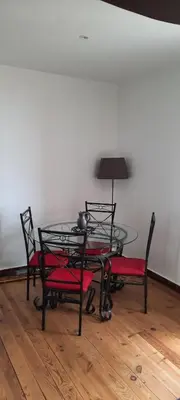 a glass table with four chairs and a table with a lamp at demeure de charme in Mazères