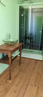 a glass sink on a wooden table next to a mirror at demeure de charme in Mazères