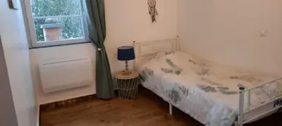 a small bedroom with a bed and a window at demeure de charme in Mazères