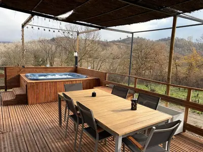 a deck with a table and a hot tub at Bulle d'Amour - Dôme avec spa privatif dans les Corbières in Durban-Corbières