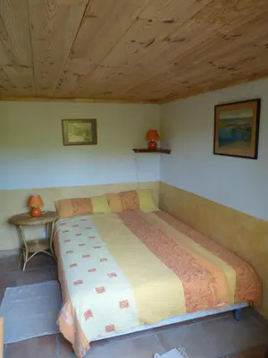 a large bed in a bedroom with a wooden ceiling at Gîtes à la Ferme - Hautes-Corbières in Termes