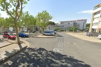 a street with cars parked in a parking lot at Mon petit studio à la mer in Gruissan