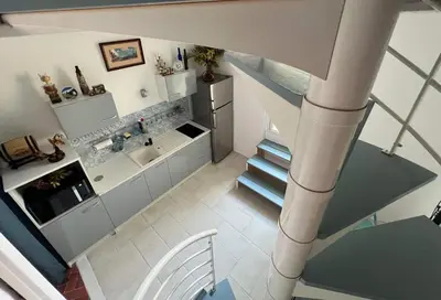 an overhead view of a kitchen and staircase in a house at Duplex proche mer, avec swimspa terrasse, jardin et barbecue in Lapalme