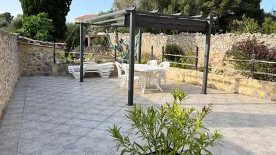 a pavilion with a table and chairs on a patio at Duplex proche mer, avec swimspa terrasse, jardin et barbecue in Lapalme