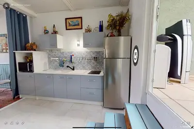 a kitchen with a stainless steel refrigerator at Duplex proche mer, avec swimspa terrasse, jardin et barbecue in Lapalme