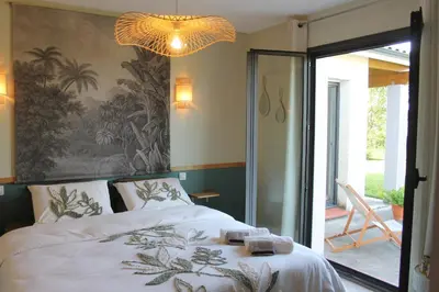 a bedroom with a bed and a chandelier at La Naillousaine in Nailloux