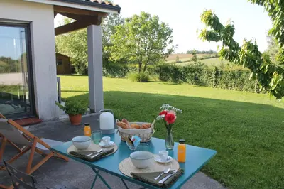 a blue table with a basket of food on a patio at La Naillousaine in Nailloux