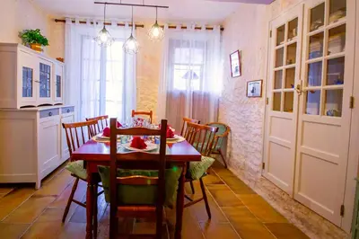 a dining room with a table and chairs in a kitchen at La Maison Bleue in Oupia