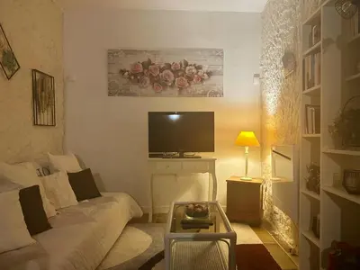 a living room with a couch and a tv at La Maison Bleue in Oupia