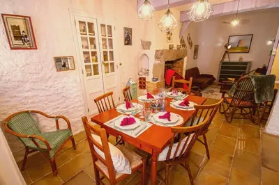 a dining room with a table and chairs at La Maison Bleue in Oupia