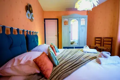 a bedroom with a bed with pillows on it at La Maison Bleue in Oupia