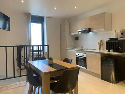 a kitchen with a table and chairs in a room at Location de vacances à Quarante Gîte de la cave Szymczak in Quarante