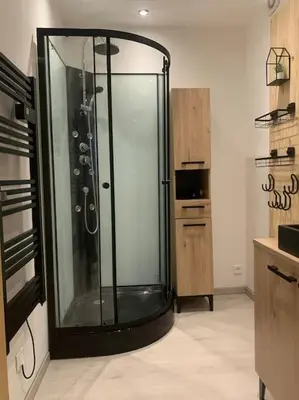 a large glass shower in a room with a kitchen at Location de vacances à Quarante Gîte de la cave Szymczak in Quarante