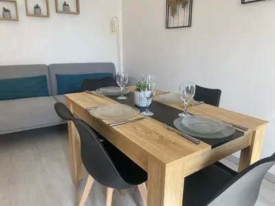 a wooden table with chairs and wine glasses on it at Location de vacances à Quarante Gîte de la cave Szymczak in Quarante