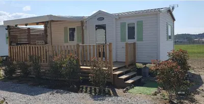 a small house with a porch and a fence at MH135 camping NOVELA - location entre particuliers- Mobil home 5pl climatisé - in Port-la-Nouvelle