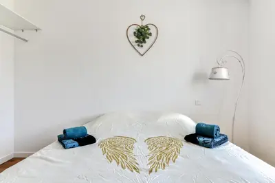 a bedroom with a white bed with wings on it at La Villa d'Isa et Seb in Narbonne