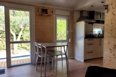 a kitchen with a table and chairs in a room at Mobil home de Patricia et Franck à Sigean in Sigean