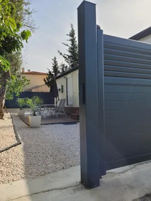a blue fence in front of a house at Mobil home de Patricia et Franck à Sigean in Sigean
