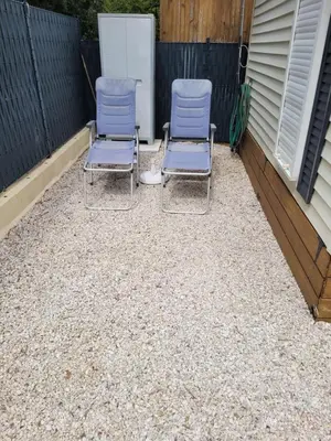 two chairs sitting on top of a gravel patio at Mobil home de Patricia et Franck à Sigean in Sigean
