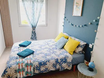 a bedroom with a bed with a blue wall at Confort et Style Maison Cosy 3 Chambres Narbonne in Narbonne