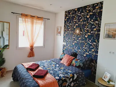 a bedroom with a bed with a blue patterned wall at Confort et Style Maison Cosy 3 Chambres Narbonne in Narbonne