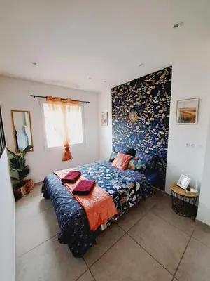 a bedroom with a bed with a blue comforter at Confort et Style Maison Cosy 3 Chambres Narbonne in Narbonne