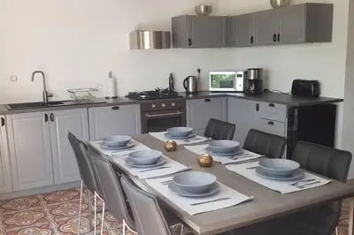 a kitchen with a wooden table with bowls and chairs at Rue Basse - village house overlooking the Pyrenees in Montréal