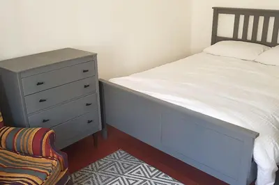 a bedroom with a bed and a dresser and a chair at Rue Basse - village house overlooking the Pyrenees in Montréal