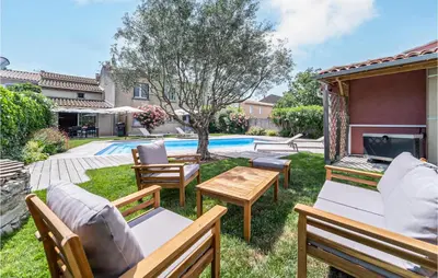 a backyard with chairs and a table and a pool at Beautiful Home In Villegly With Kitchen in Villegly