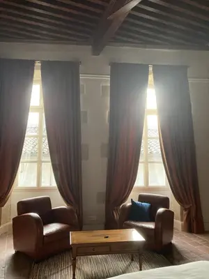 a living room with two chairs and two windows at Les Ordalies in Castelnaudary